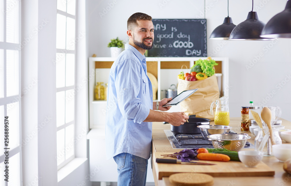 Smiling and confident chef standing in large kitchen Smiling and confident chef standing in large kitchen