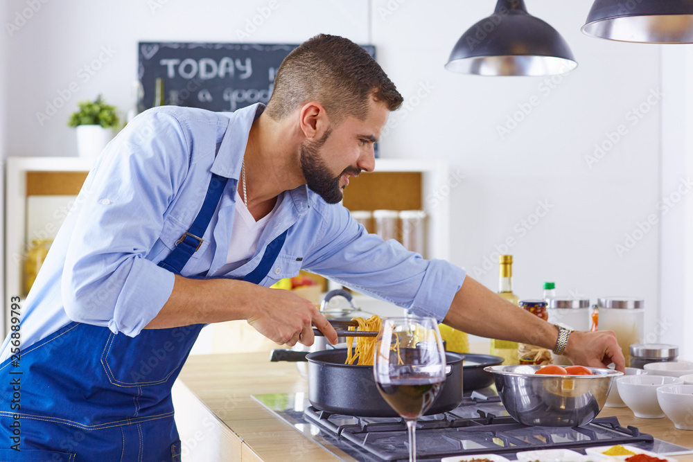 Smiling and confident chef standing in large kitchen Smiling and confident chef standing in large kitchen