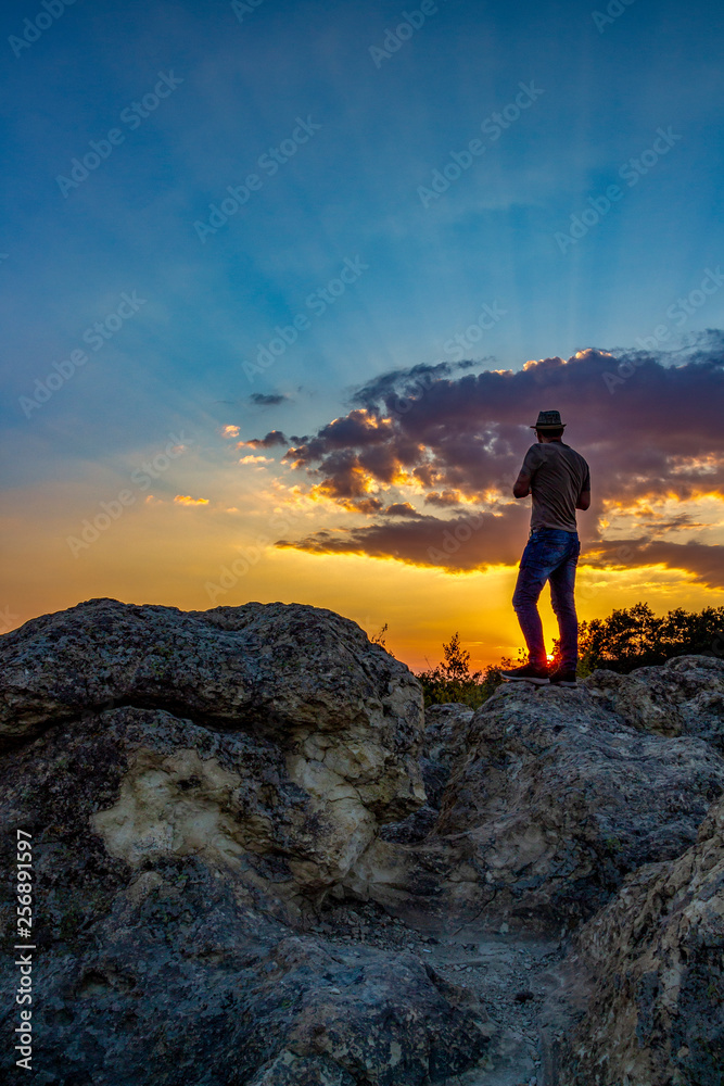 Rear view of unrecognizable male photographer admiring the sunset over the Stone Mushrooms near Beli Plast village, Kardzhali Municipality, Bulgaria