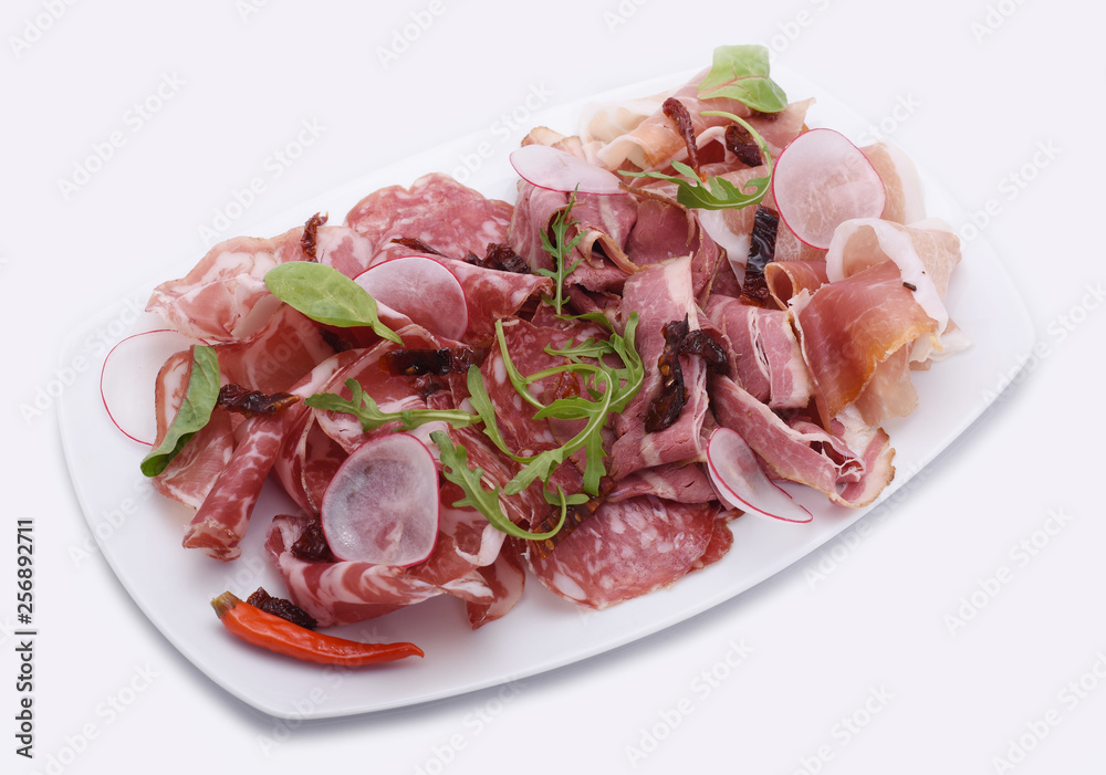 White plate with Thinly Sliced Salam sliced ​​ham, prosciutto with arugula leaves and radish on a white background