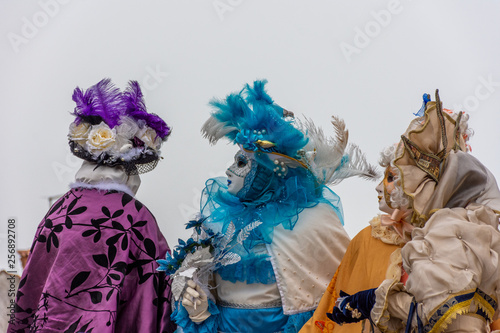 Italy, Venice, 2019, carnival, people with beautiful masks walk around Piazza San Marco, in the streets and canals of the city, posing for photographers and tourists, with colorful clothes.