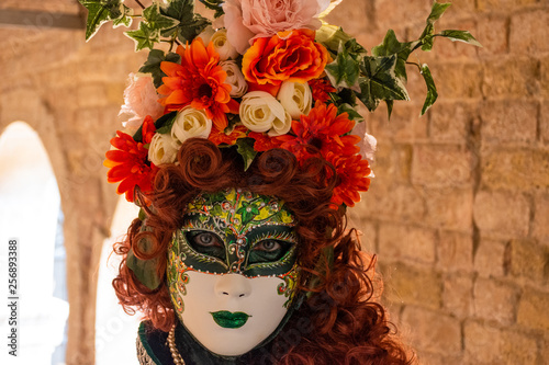 Fototapeta Naklejka Na Ścianę i Meble -  Italy, Venice, 2019, carnival, people with beautiful masks walk around Piazza San Marco, in the streets and canals of the city, posing for photographers and tourists, with colorful clothes.