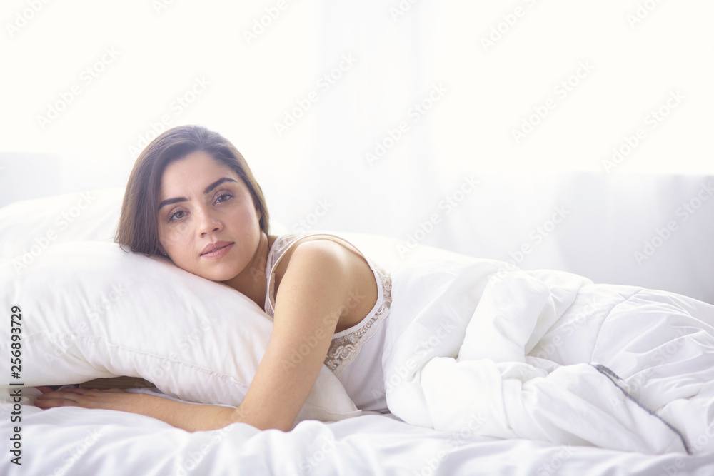beautiful young woman basking in bed in the morning. Beautiful beautiful young woman basking in bed in the morning. Beautiful