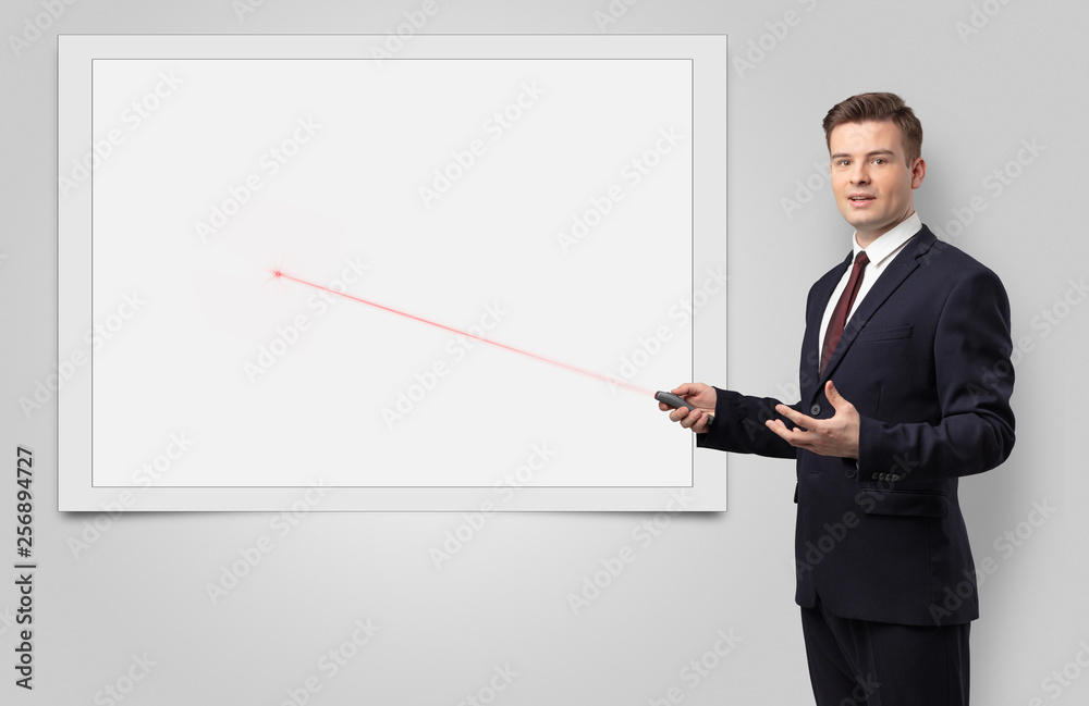 Young businessman with laser pointer and copyspace white blackboard Young businessman with laser pointer and copyspace white blackboard