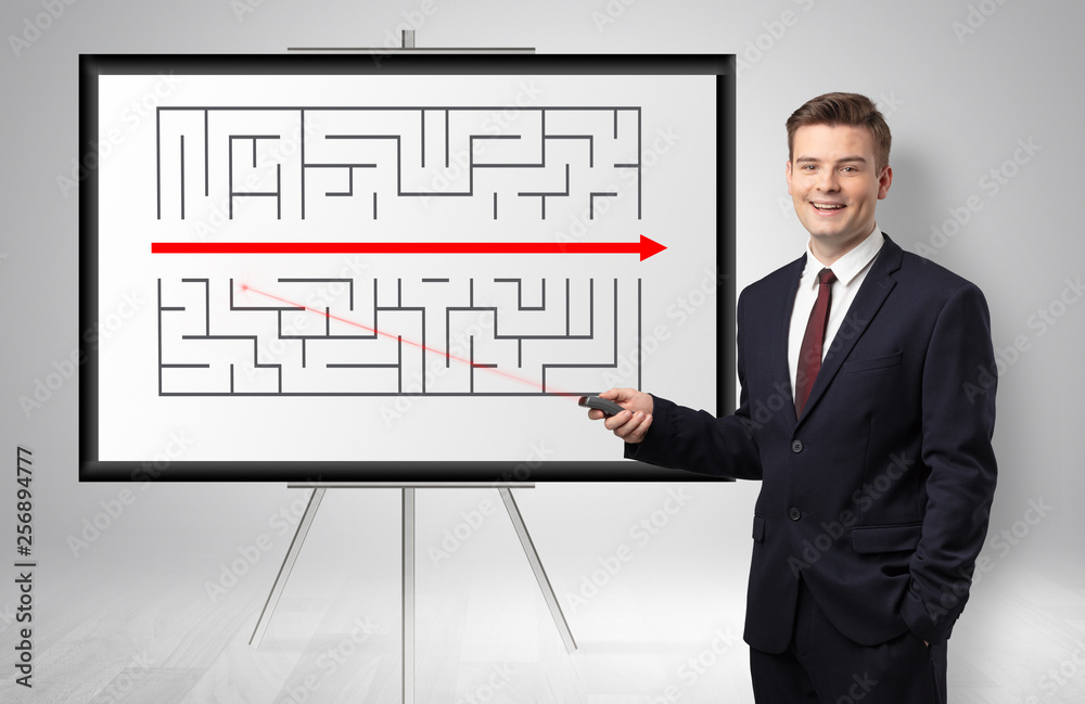 Handsome businessman with laser pointer presenting potential exit from a labyrinth
Handsome businessman with laser pointer presenting potential exit from a labyrinth