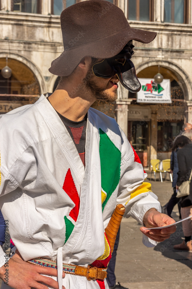 Italy, Venice, 2019, carnival, people with beautiful masks walk around Piazza San Marco, in the streets and canals of the city, posing for photographers and tourists, with colorful clothes.