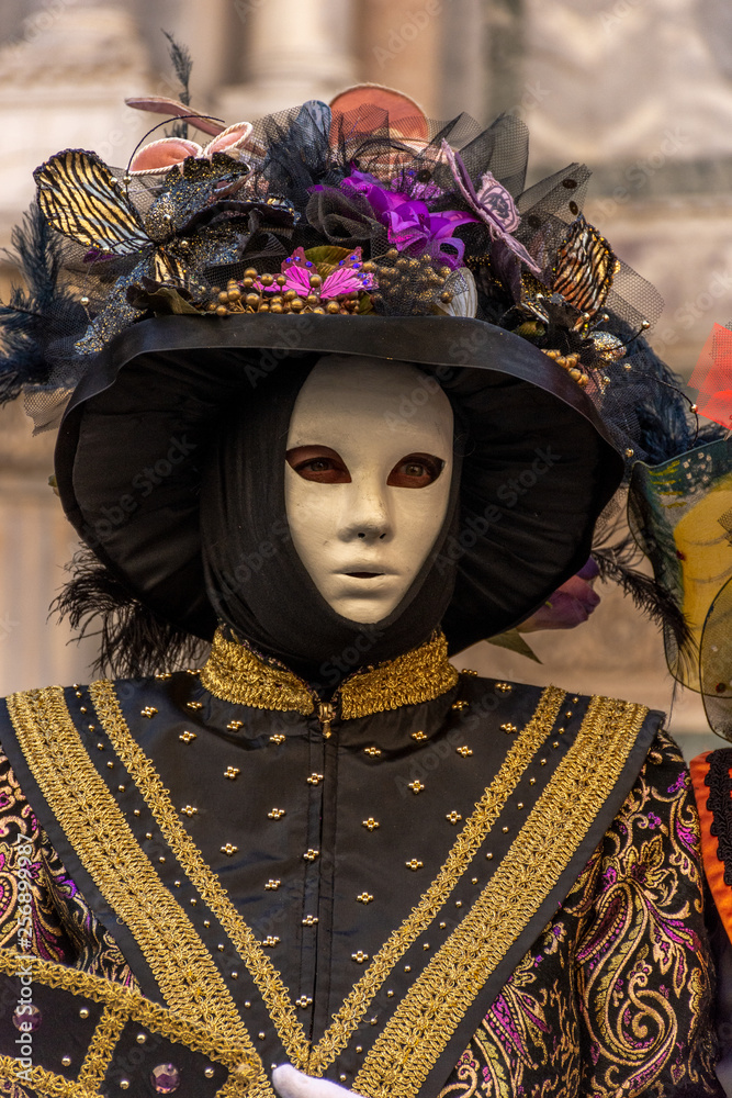 Italy, Venice,  carnival,  2019,  people with beautiful masks walk around Piazza San Marco, in the streets and canals of the city, posing for photographers and tourists, with colorful clothes.