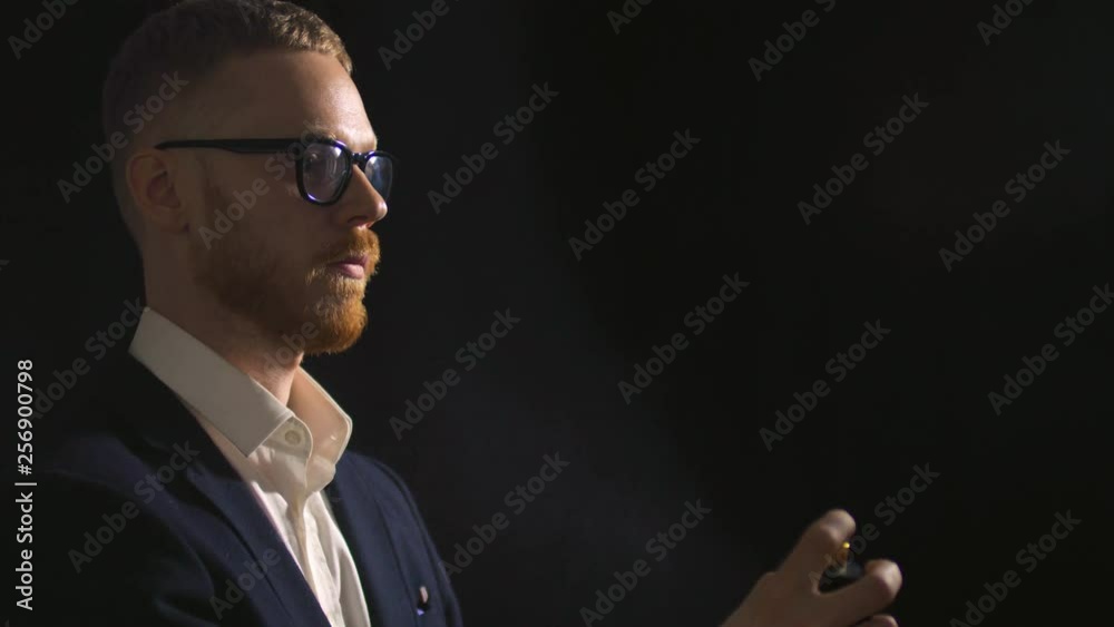 Portrait of successful businessman applying perfume Portrait of successful businessman applying perfume