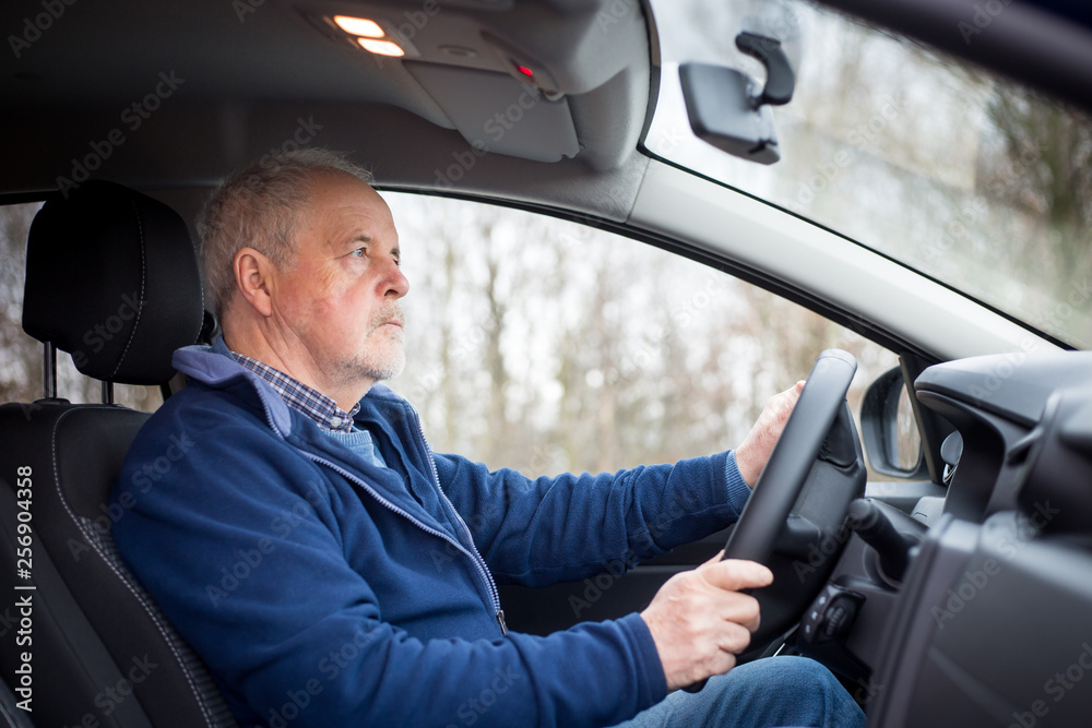An old senior man driving a modern car, transportation concept An old senior man driving a modern car, transportation concept