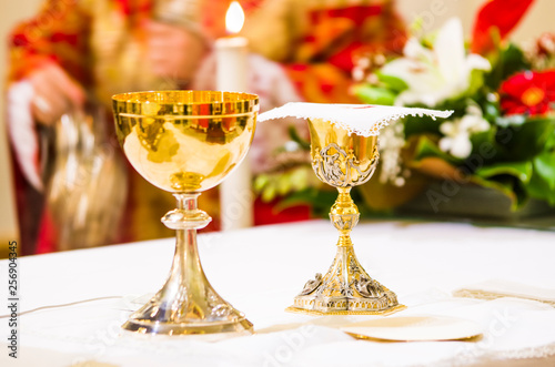 cup with wine and ciborium with host on the altar of the holy mass photo