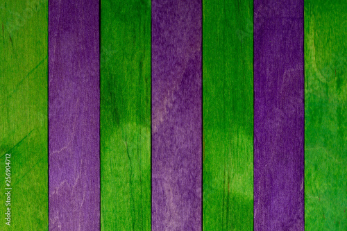 Beautiful texture of natural wood slats of green and purple colors. Natural and aged appearance.