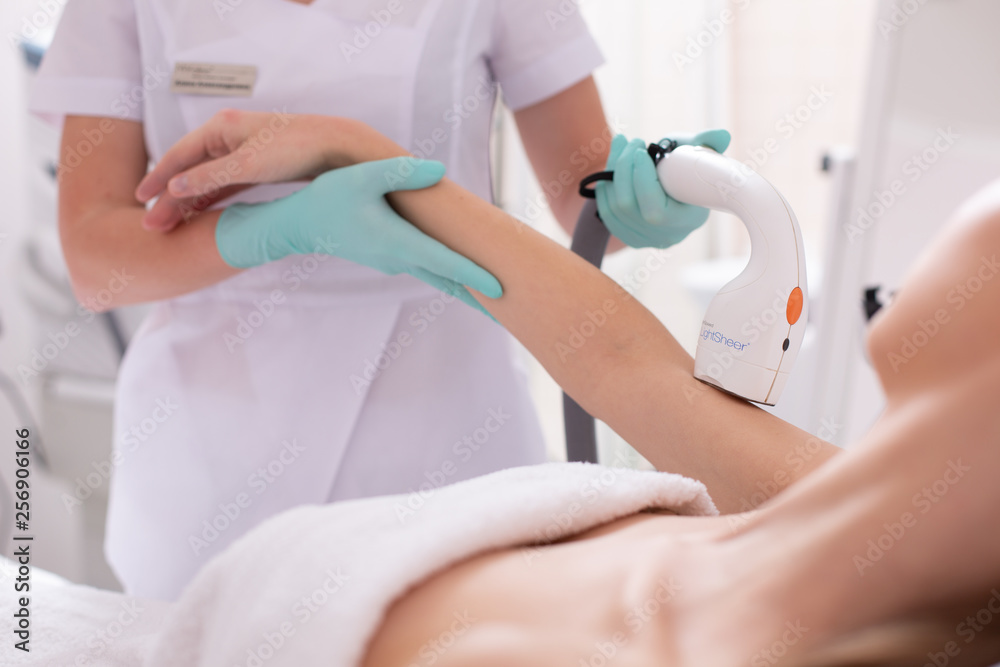 Obraz premium Careful beautician holding hand of woman at the hair removal