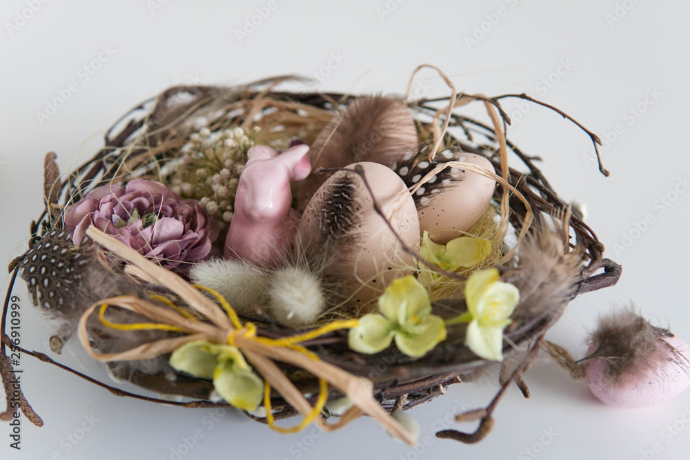 Small pink easter bunny in basket with eggs and easter decorations Small pink easter bunny in basket with eggs and easter decorations