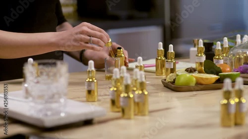 Close up of perfumer adding essential oil in beaker photo