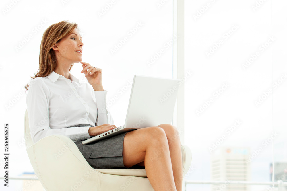 Corporate executive woman using laptop in contemporary location Corporate executive woman using laptop in contemporary location