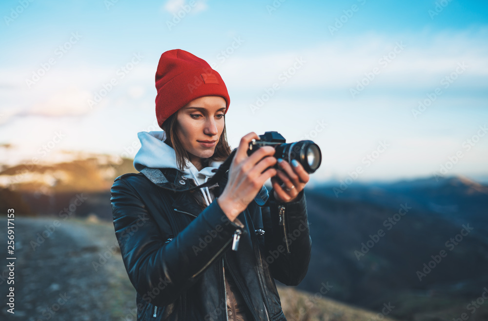 hipster tourist girl hold in hands take photography click on modern photo camera, photographer look on camera technology, journey landscape vacation concept, sun flare mountain - obrazy, fototapety, plakaty 