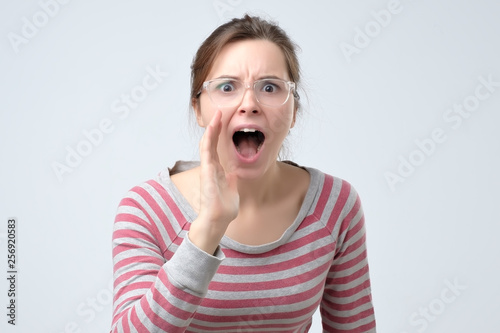Young woman shouting trying to be loud.