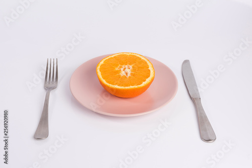 half an orange on a plate isolated on white background