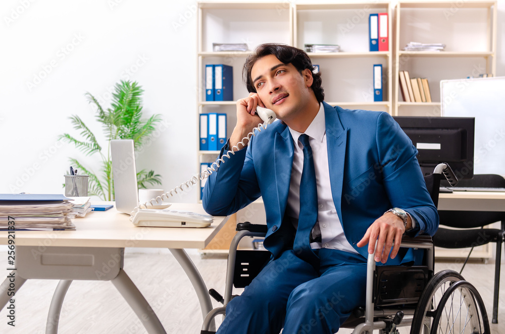 Male employee in wheelchair working at the office Male employee in wheelchair working at the office