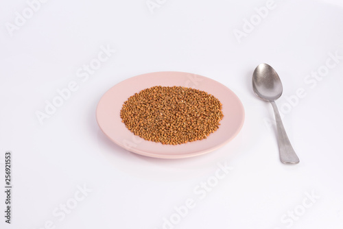 Fototapeta Naklejka Na Ścianę i Meble -  buckwheat groats on a plate isolated on white background