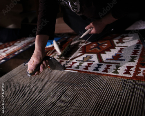 Weaving carpet with traditional techniques on a loom. Wool yarns used as a warp and weft is crucial for this art.Turkey