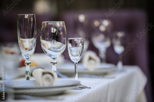 close up photo of a set of glasses for wine, champagne and cognac on a arranged table for a event