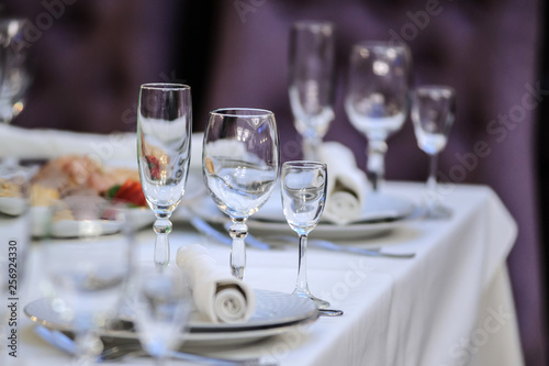 close up photo of a set of glasses for wine, champagne and cognac on a arranged table for a event