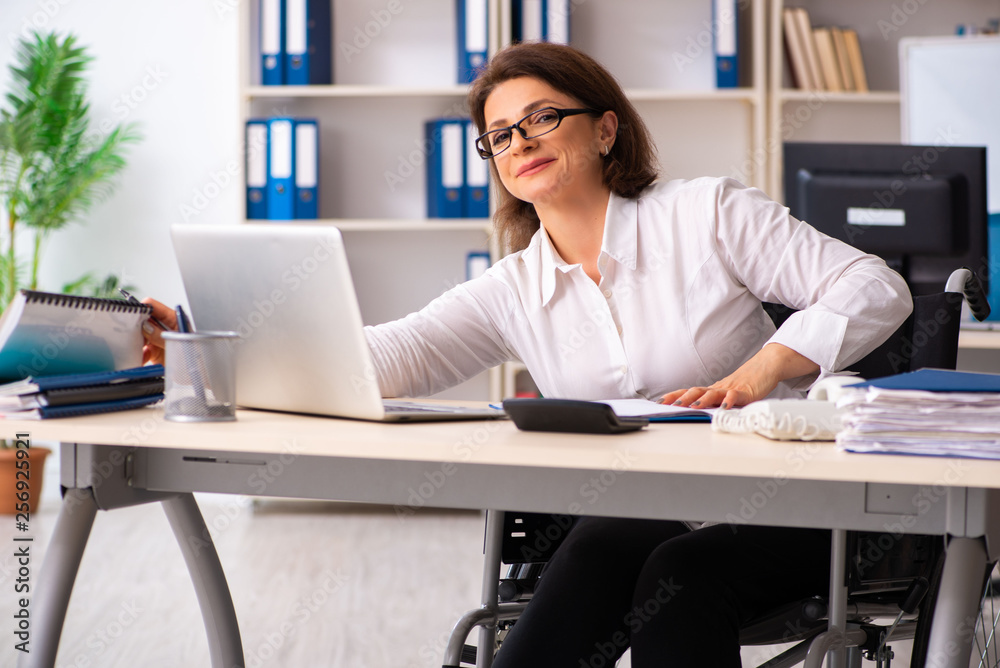 Female employee in wheel-chair at the office Female employee in wheel-chair at the office