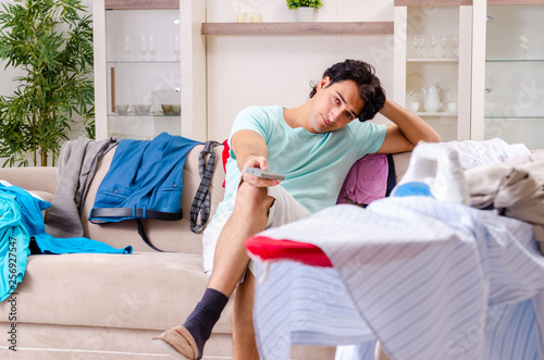 Young man husband ironing at home