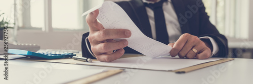 Photos Wide view image of financial adviser sitting at his desk working