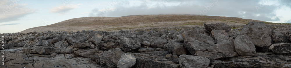 Panorama, Burren national park, county Clare, Ireland. Rocks and stones, mountain peak in the background. Panorama, Burren national park, county Clare, Ireland. Rocks and stones, mountain peak in the background.