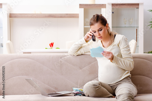 Young pregnant woman in budget planning concept