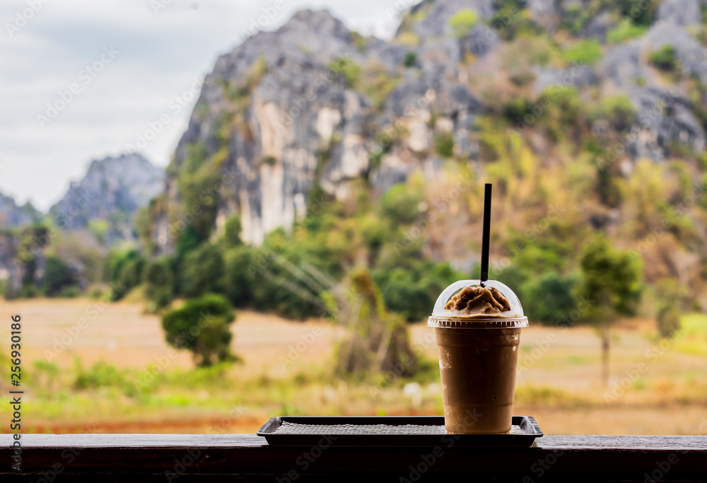Fototapeta premium Cold coffee amid nature and mountains