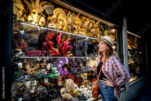 Young woman who chois a Venetian mask in shop photo