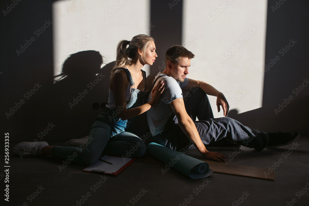 Repair, building and home renovation concept - smiling couple measures wallpaper. Preparing to wall covering. Happy family and friendship Repair, building and home renovation concept - smiling couple measures wallpaper. Preparing to wall covering. Happy family and friendship