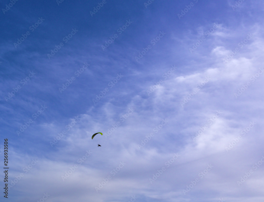 Fototapeta premium Paraglider flying, deep blue sky with some clouds. Clean Monday holiday. Athens, Greece 2019.