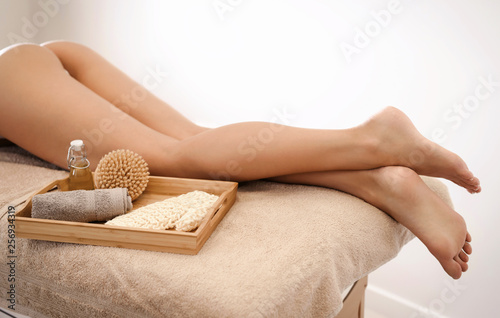 Young woman with slim perfect body and clear skin relaxing after foot massage in beauty spa salon, close up view. Copyspace for text