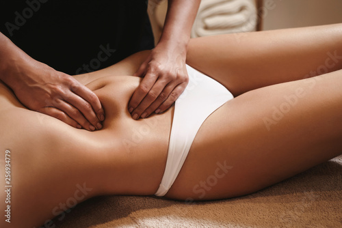 Anti cellulite belly massage for young woman in beauty salon. Perfect skin fat burning beauty concept