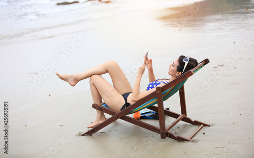 summer beach vacation concept, woman  tourist sit relaxation on summer chai on beach