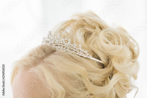 Hairstyle with a tiara (crown). Hair dressing for the bride with a crown (tiara). The precious crown on the hair of the girl. Close-up.