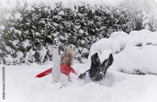 Mother and son jumping in deep snow  having fun
