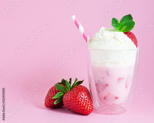Strawberry smoothie or milkshake with whipped cream and strawberry fruit on pink background. Healthy food for breakfast and snack.