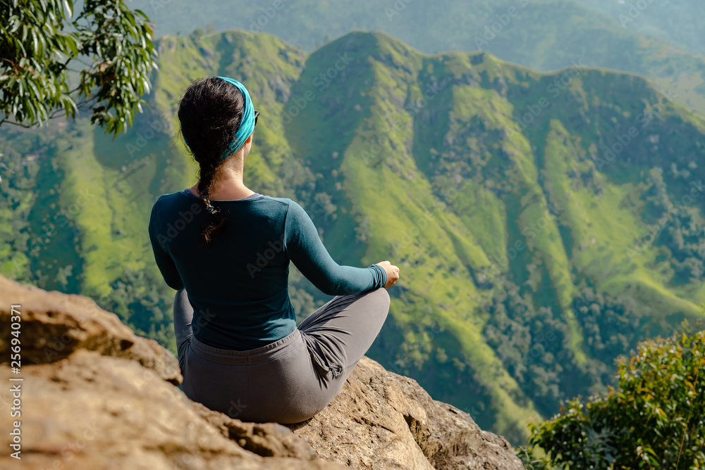 Naklejka premium The girl at the top is engaged in yoga tourist.