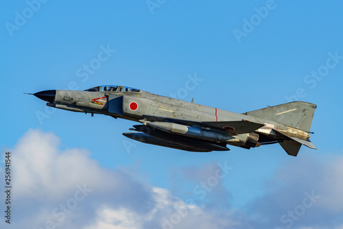 Obraz na plátne jet fighter F-4 Phantom over white cloud in blue sky