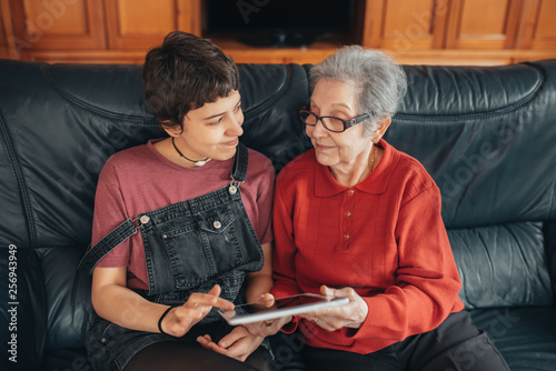 Granddaughter teaches her grandmother how to use a tablet