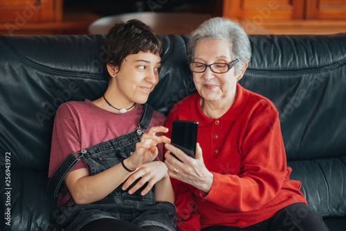 Granddaughter teaches her grandmother how to use a mobile phone