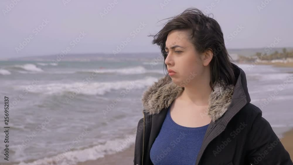 portrait of Depressed thoughtul lonely woman walking on the beach in a windy day portrait of Depressed thoughtul lonely woman walking on the beach in a windy day