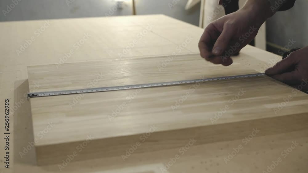 Close up shot of man who measures a wooden part Close up shot of man who measures a wooden part