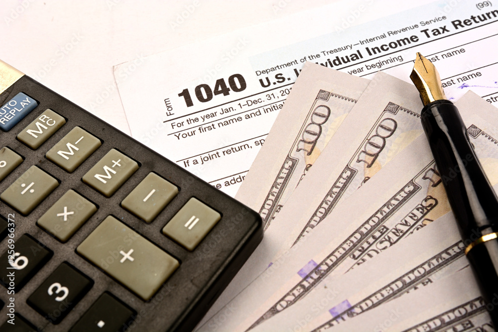 Calculating US tax with 1040 tax form on white background Calculating US tax with 1040 tax form on white background