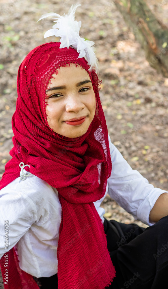  Women muslim, women islamic,wearing a red fabric head covering adorn with white fabric flowers wear shirt white photography portrait close up the face before to ramadan month.